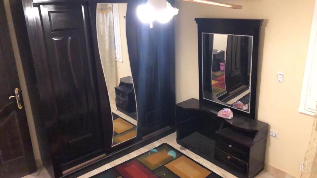 Cette chambre comprend deux miroirs et une porte marron. dans l'établissement احجزلى, à Ville du 6 Octobre