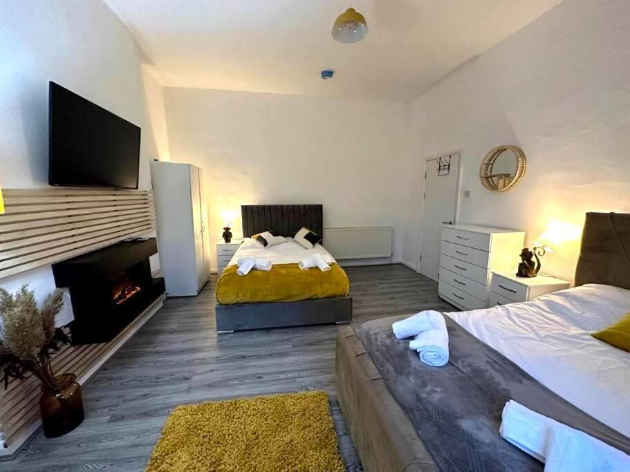 a large bedroom with two beds and a fireplace at Stratford Stay - sleeps up to 9 near City Centre with parking in Birmingham