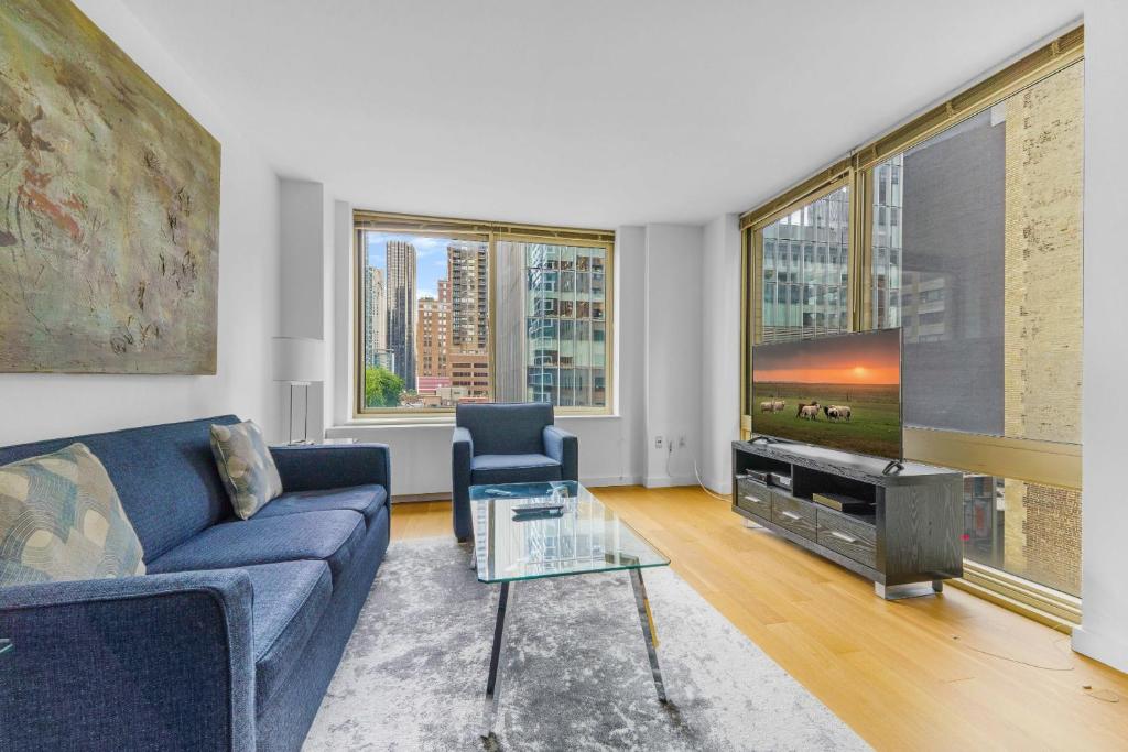 uma sala de estar com um sofá azul e uma televisão em Global Luxury Suites at The Marc em Nova York