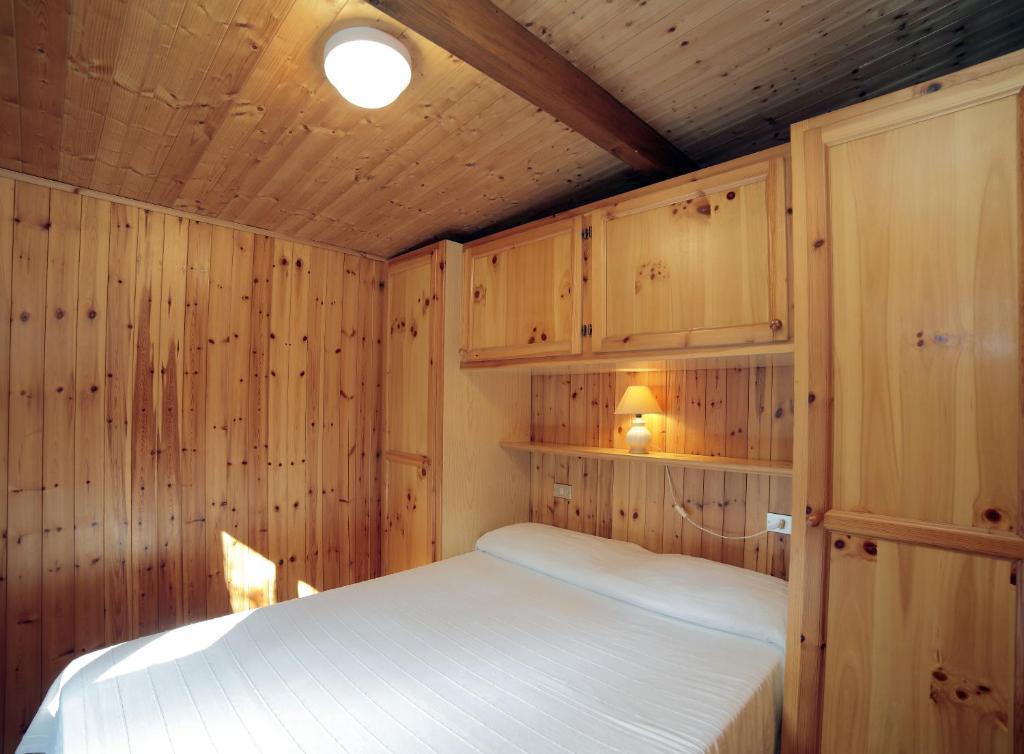 a bedroom with a bed in a wooden cabin at Il Frantoio Camping in San Bartolomeo al Mare