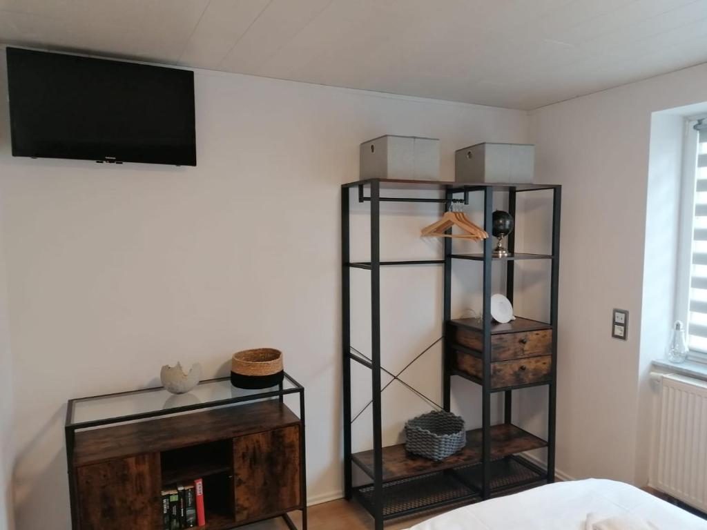 sala de estar con TV y estante de libros en Ferienappartement Bodekessel, en Thale