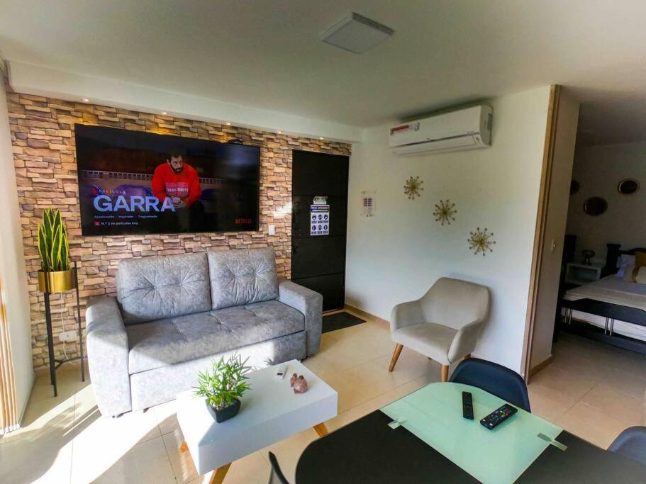 a living room with a couch and a tv at Descanso y confort 2 in La Tebaida