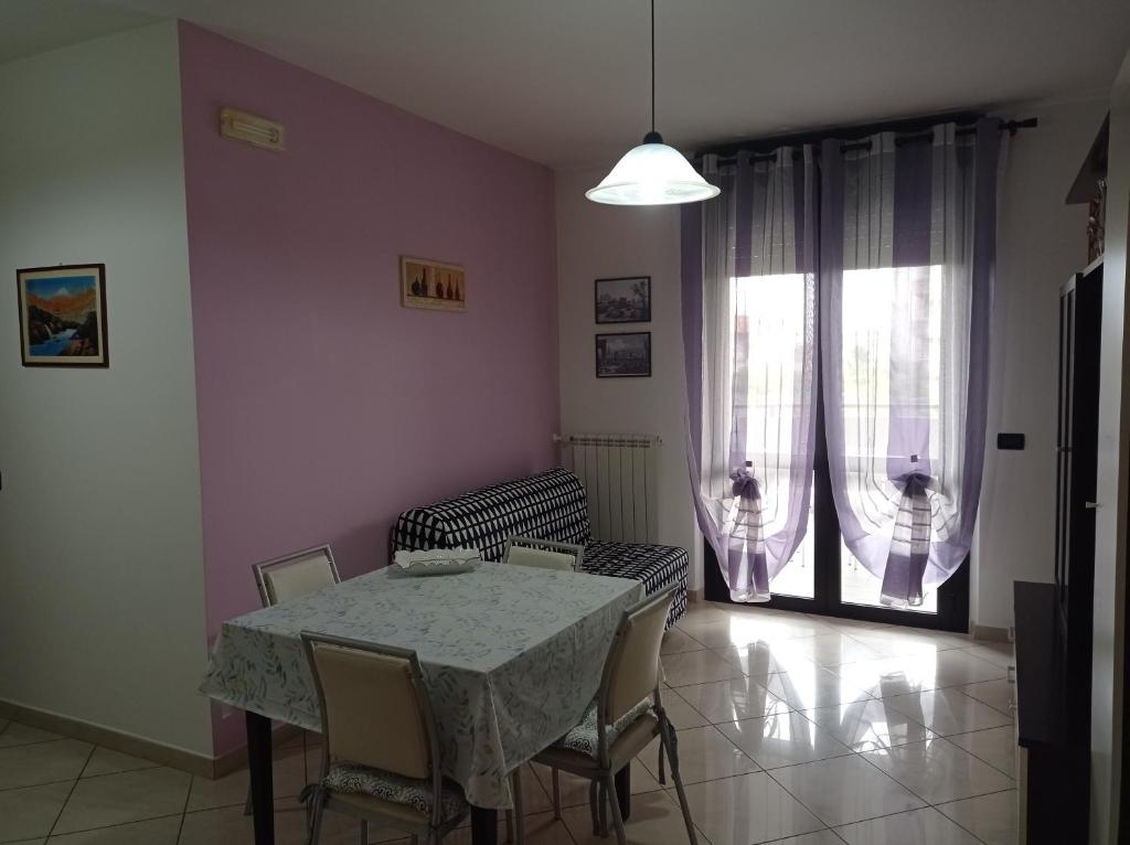 jadalnia ze stołem i krzesłami oraz oknem w obiekcie Appartamento tra mare e città w mieście Vasto