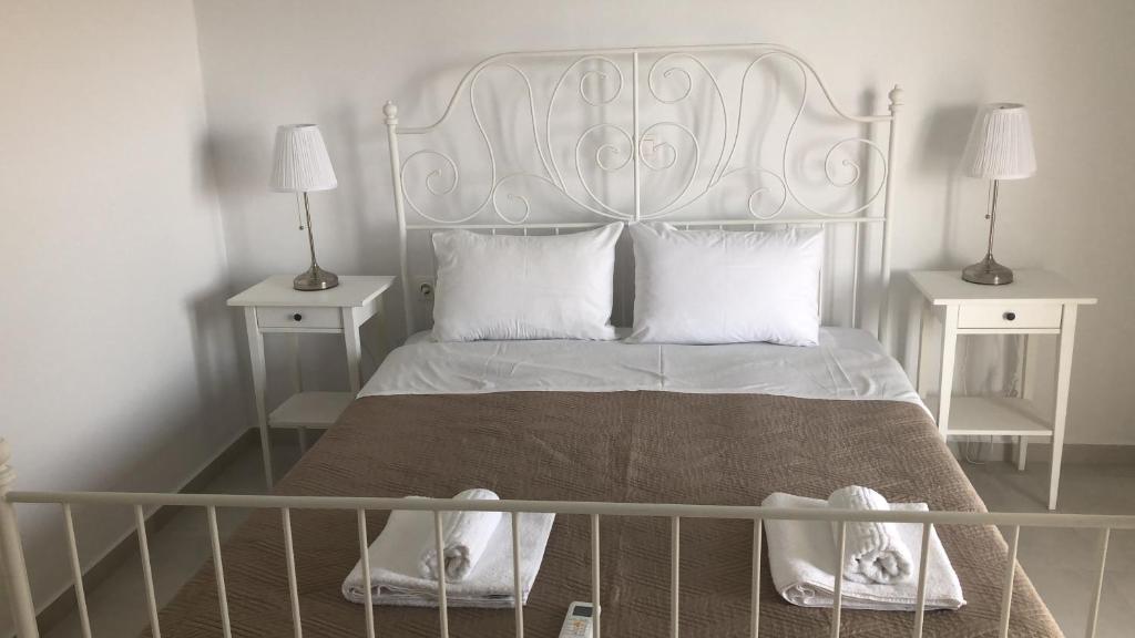 un letto bianco con testiera bianca e due comodini di Sunset Bungalows a Falasarna