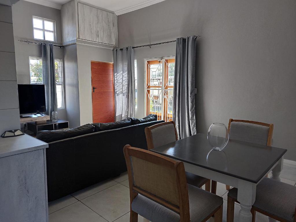 a living room with a table and a couch at Grassland 4 (Townhouse) in Bloemfontein