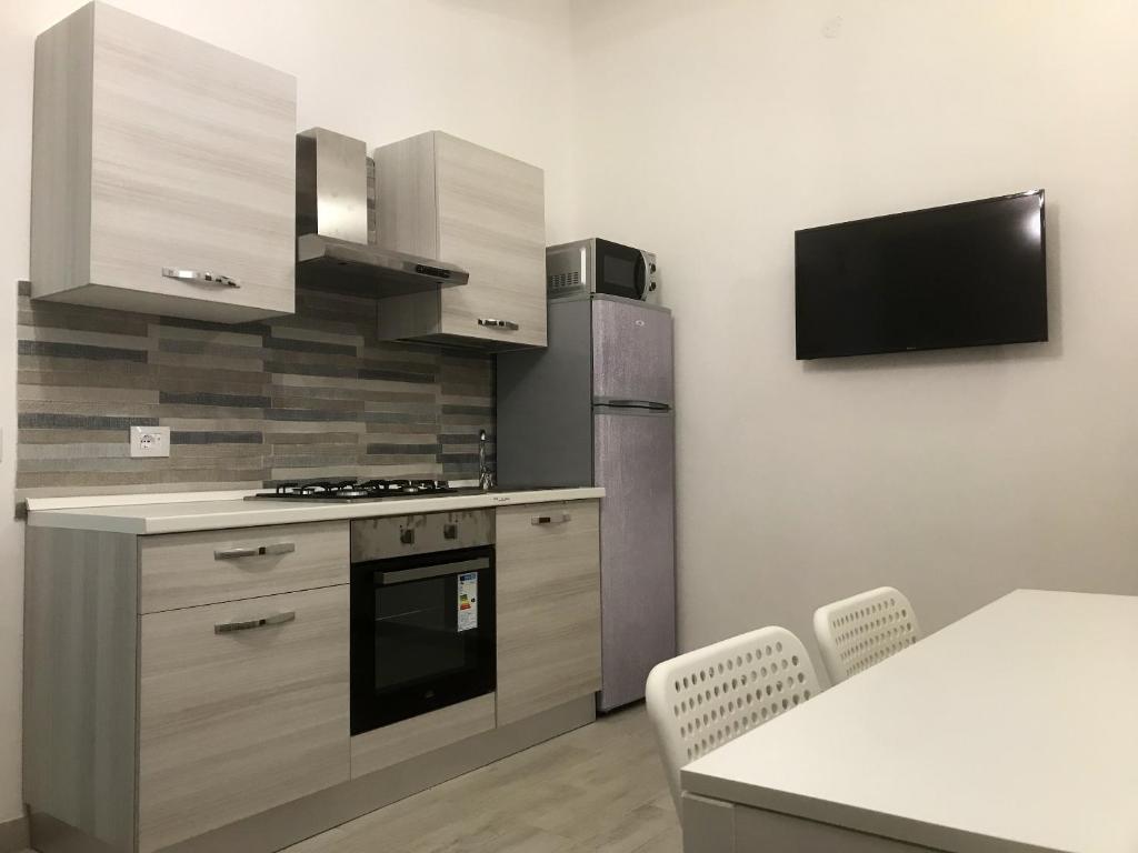 a kitchen with stainless steel appliances and a table with chairs at One bedroom house with sea view enclosed garden and wifi at Ribera 5 km away from the beach in Ribera