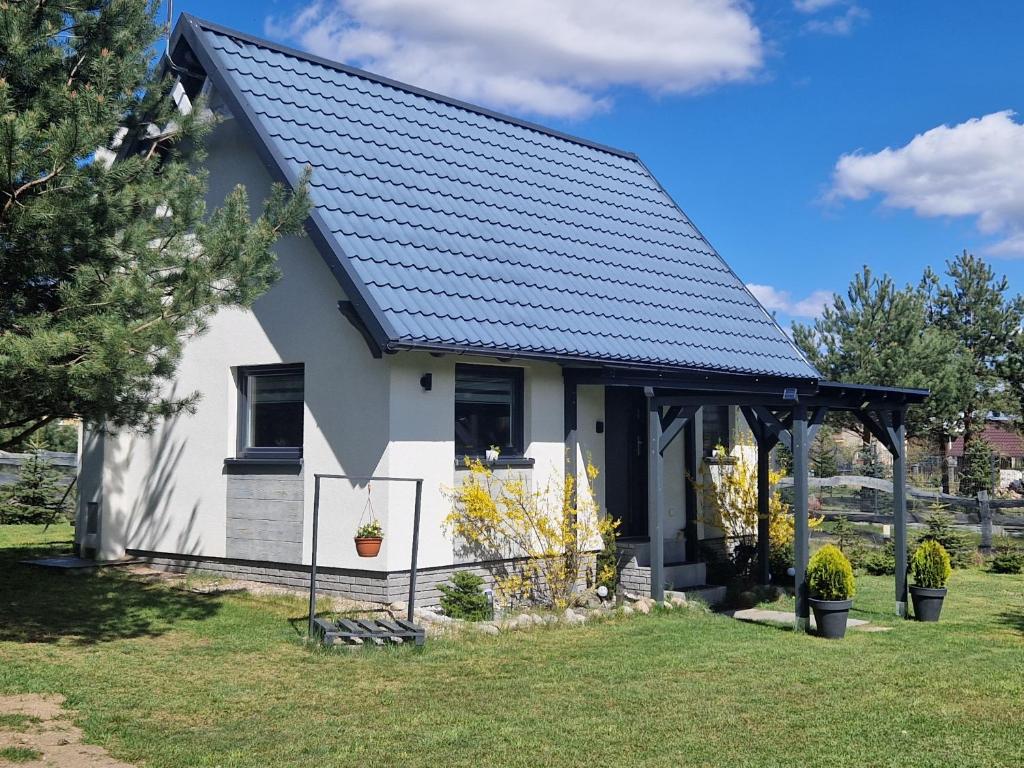 una pequeña casa blanca con techo negro en Domek Konrad - balia ogrodowa dodatkowo płatna, en Kościerzyna