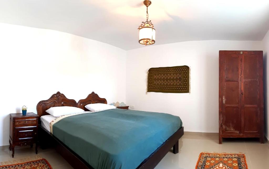 a bedroom with a bed with a blue bedspread at Chez Ayedi - central and familiar atmosphere next to beach in Hammam Chott