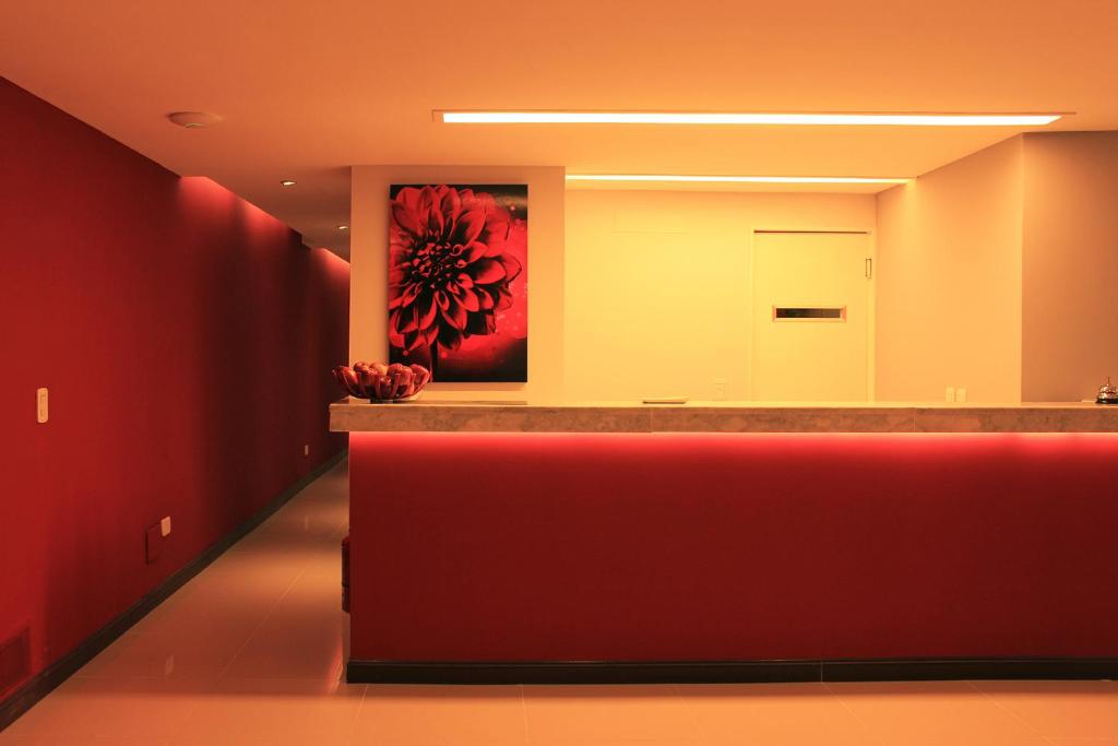 1412 Hotel Boutique في روزاريو: لوبي مع كونتر احمر ولوحة على الحائط