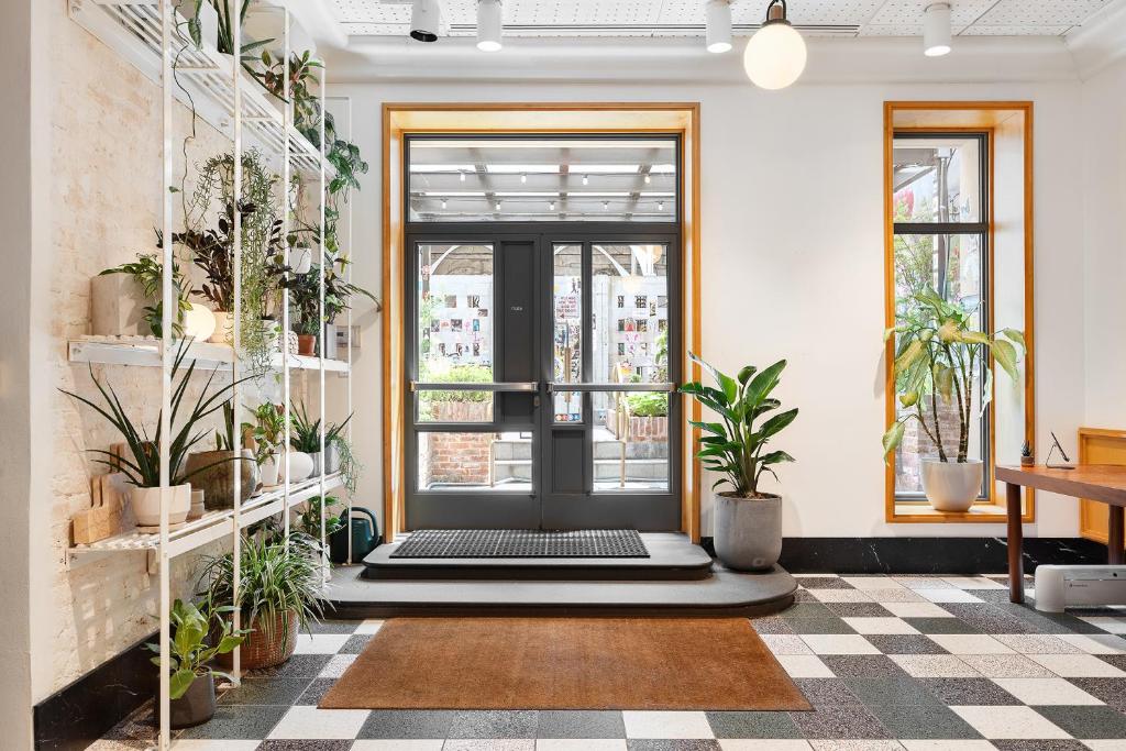 une chambre avec des plantes en pot et une porte noire dans l'établissement UNTITLED 3 Freeman Alley, à New York