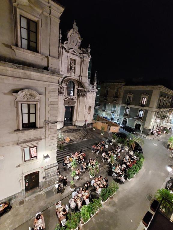 un grupo de personas sentadas fuera de un edificio en Terrazza San Camillo, en Catania
