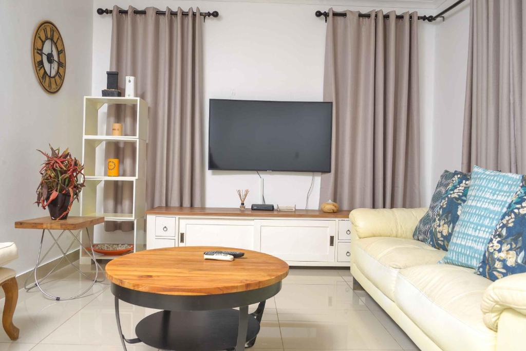 a living room with a couch and a tv at acaciaoptimumstay in Gaborone