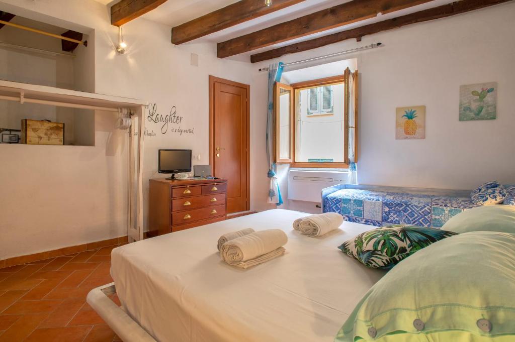 una camera da letto con un letto e asciugamani di DeRy Alghero Holiday Gilbert ad Alghero