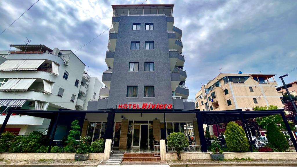 un grand bâtiment avec un hôtel en face dans l'établissement Hotel RivierA, à Durrës