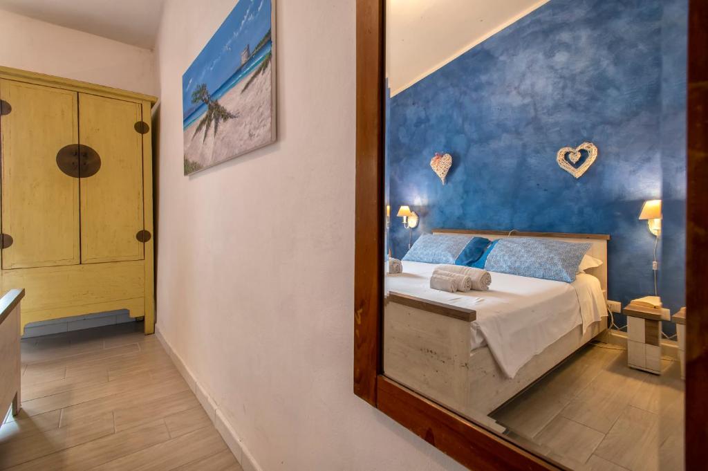 a bedroom with a bed and a mirror at Dery Alghero Holiday La Torre in Alghero