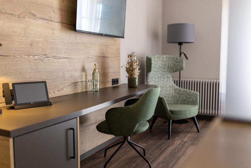 a room with a desk and two chairs and a television at Lieb&Wert in Raesfeld