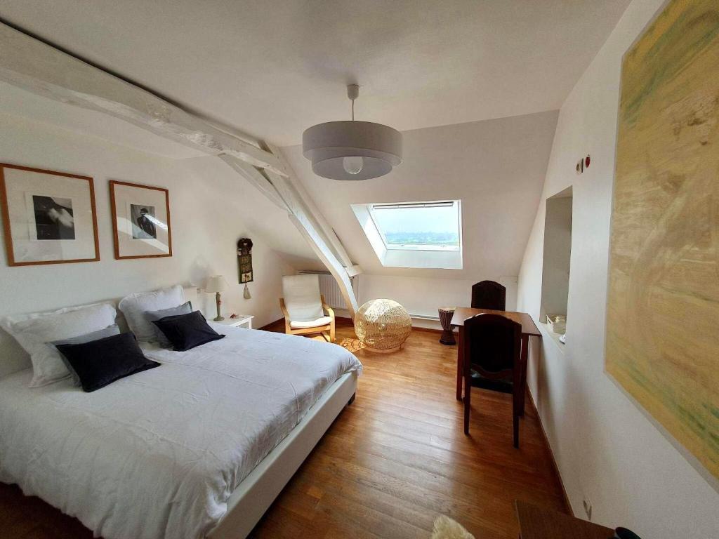 a bedroom with a bed and a desk and a window at Chambre Nuage in Étroeungt