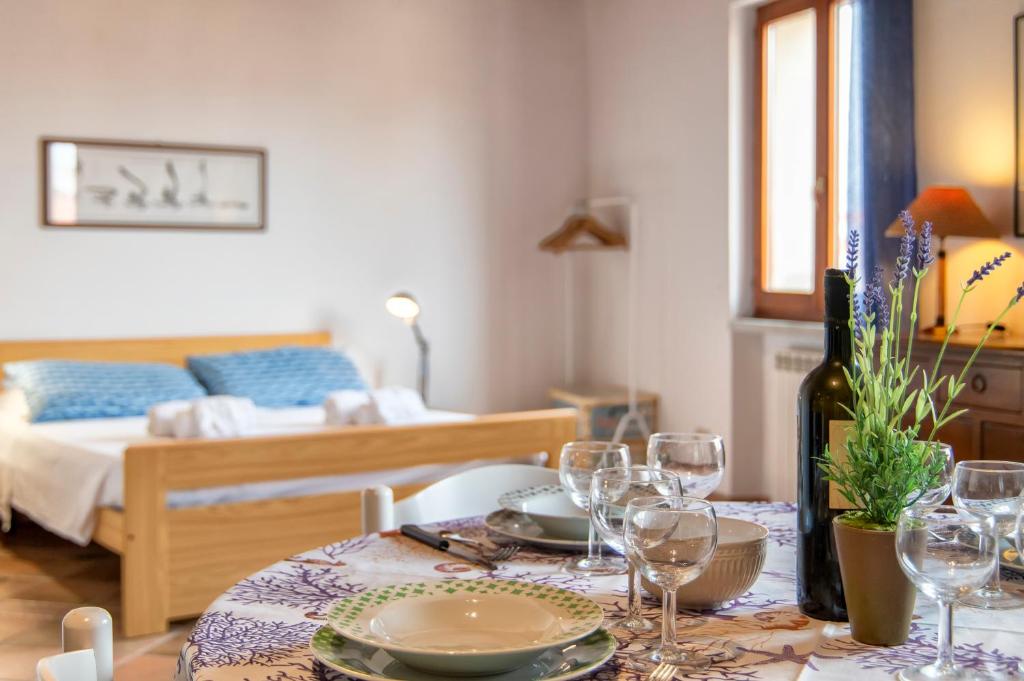 a dining room table with wine glasses and a bed at Alghero Gilbert Ferret in Alghero