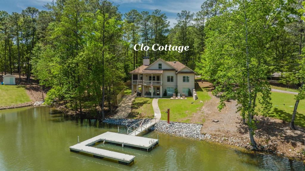 una vista aérea de una casa con un barco en el agua en The Clo Cottage on Lake Martin, en Dadeville