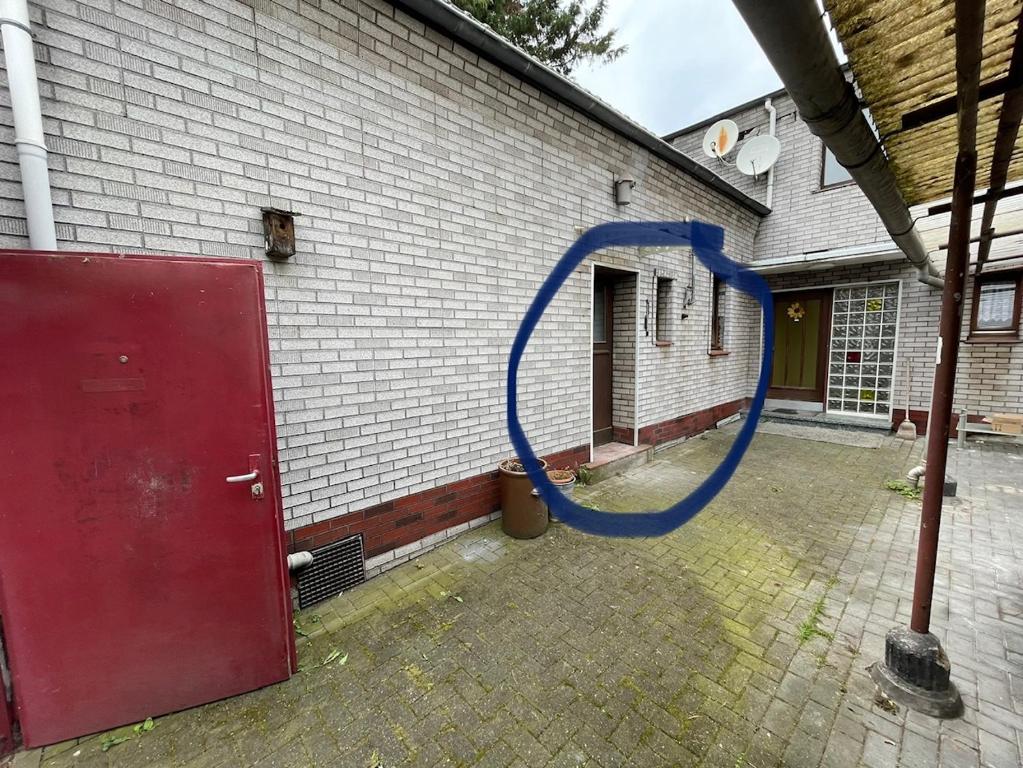 a blue hose is attached to a brick building at Bollgarten 8 in Cologne
