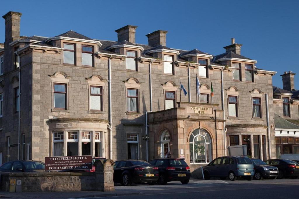 a large brick building with cars parked in front of it at Stotfield Hotel in Lossiemouth