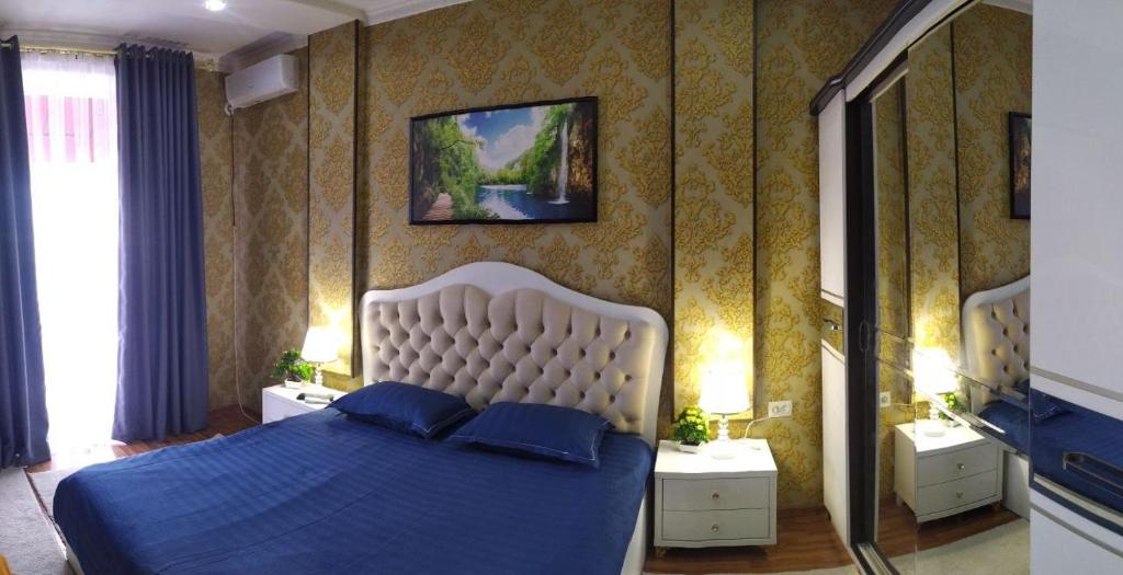 um quarto com uma cama azul e 2 almofadas azuis em Apartment near Tashkent metro station and convenient location em Tashkent