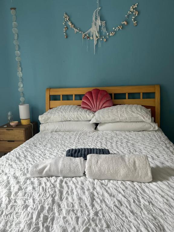 1 dormitorio con 1 cama con 2 toallas en The Shell House en Falmouth