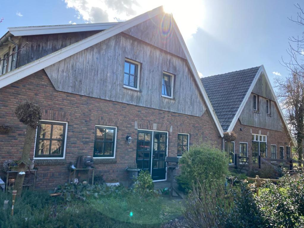 una gran casa de ladrillo con techo de gambrel en B&B Erve Möskert, en Geesteren