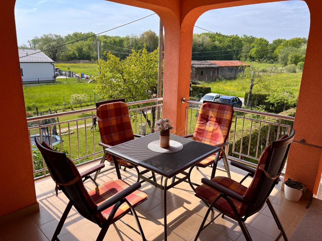 a porch with a table and chairs on a balcony at Apartman Magnolia in Petrovina Turopoljska