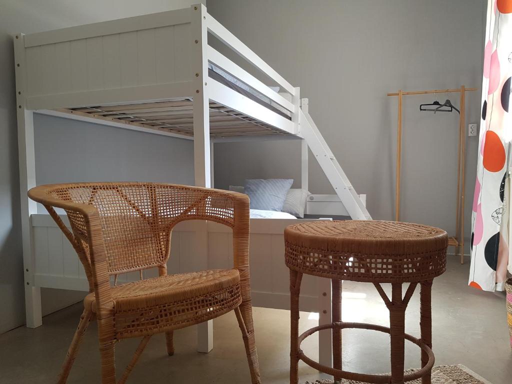 Un dormitorio con una litera con una silla y una mesa en Sleeptide, en Husum