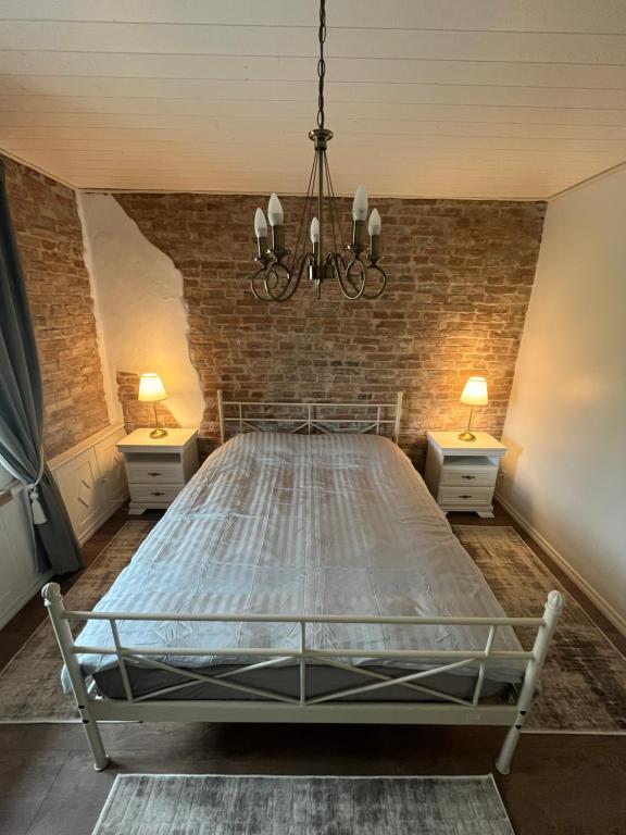 a large bed in a room with a brick wall at Aadma Guesthouse in Hiiumaa