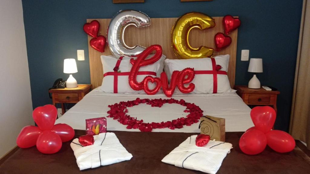 a bedroom with a bed with a love sign and balloons at Pousada Renovo da Serra in São Pedro da Serra