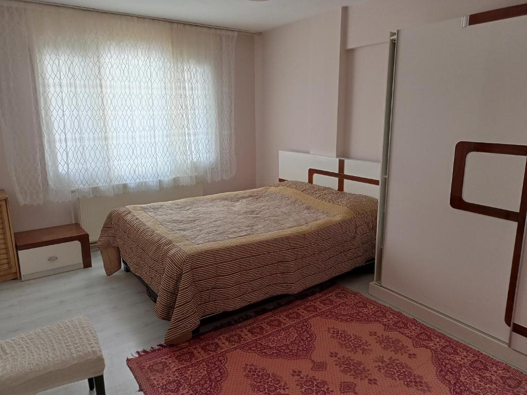 a bedroom with a bed and a window and a rug at Sky IZMIR Center Big Suit Home in İzmir