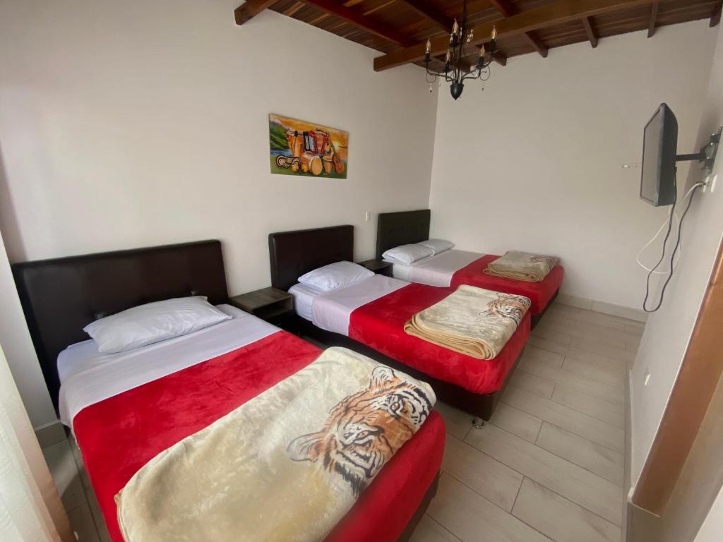 two beds sitting in a room with at HOTEL MI CASA DEL NORTE in Santa Rosa de Osos