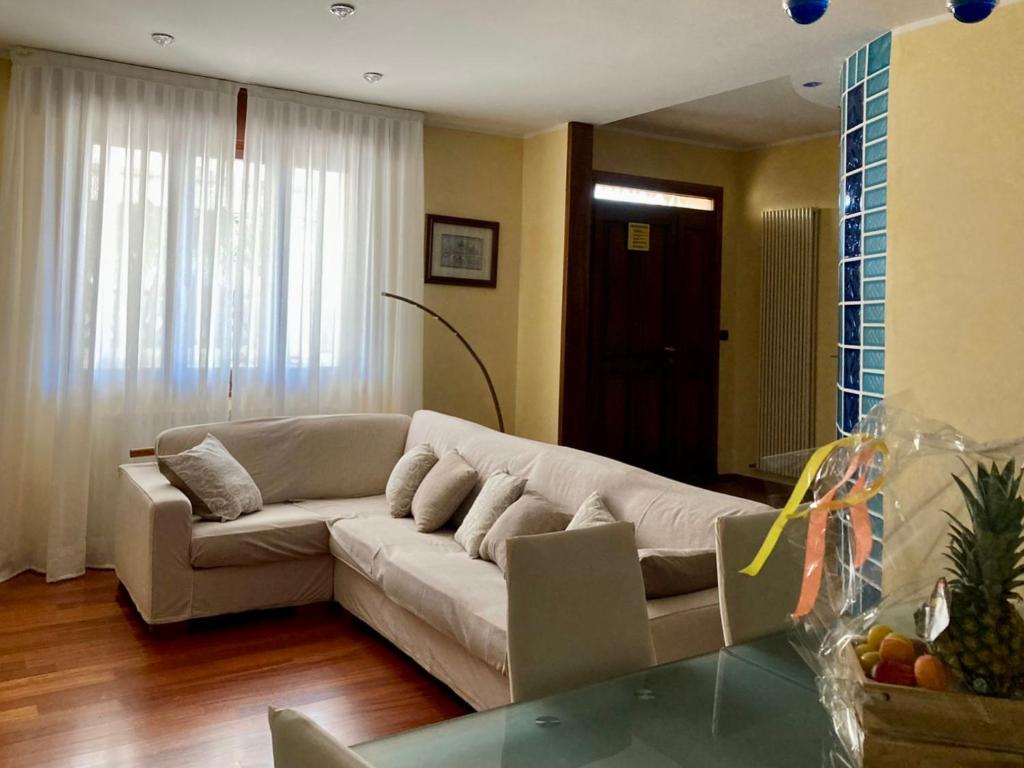 een woonkamer met een bank en een glazen tafel bij Chilli House in Sottomarina