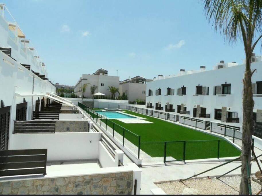 a resort with a green lawn in front of a building at Bahia Homes Torrevieja in Torrevieja