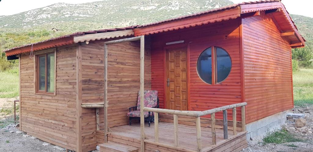 eine kleine Holzhütte mit einer Veranda und einem Fenster in der Unterkunft Olympos wood house in Kumluca