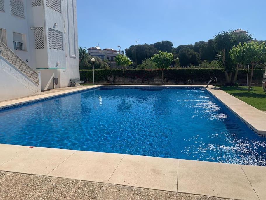 duży niebieski basen obok budynku w obiekcie Lovely Tona w mieście Torremolinos
