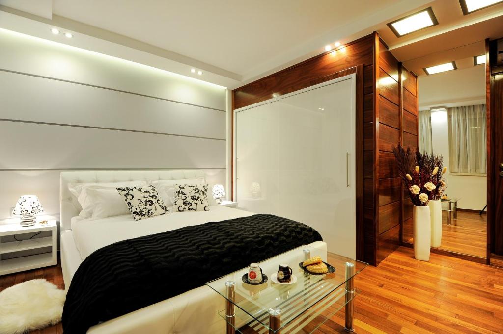a bedroom with a bed and a glass table at Main Street Studio and Rooms in Zadar