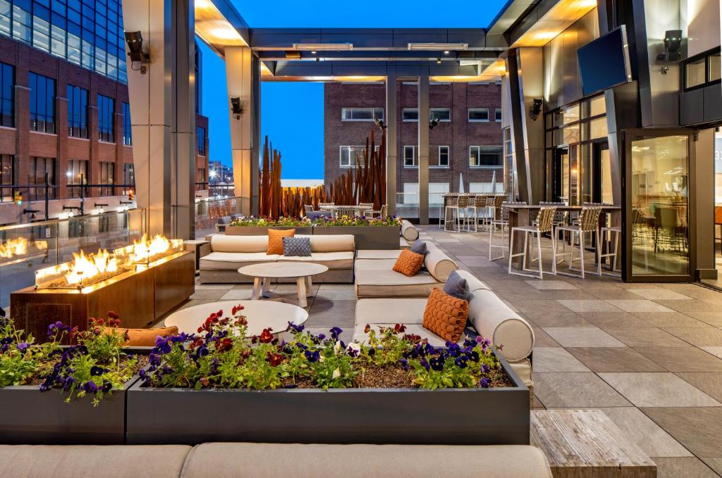 un patio all'ultimo piano con tavoli e fiori su un edificio di Hyatt House Indianapolis Downtown a Indianapolis