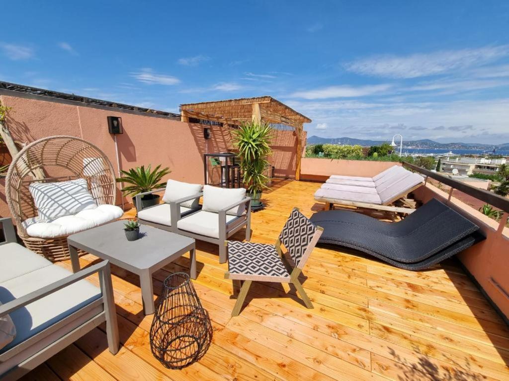 un patio all'ultimo piano con sedie e tavoli su un balcone di Superbe appartement avec Rooftop privé a Saint-Tropez