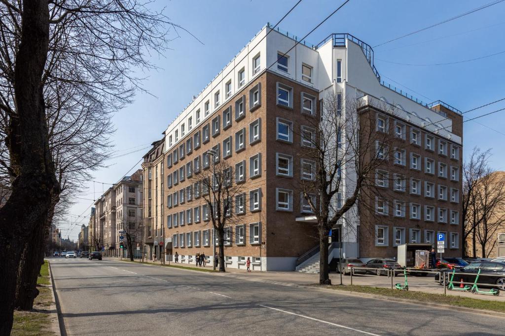 duży ceglany budynek po stronie ulicy w obiekcie Balcia Residence w Rydze