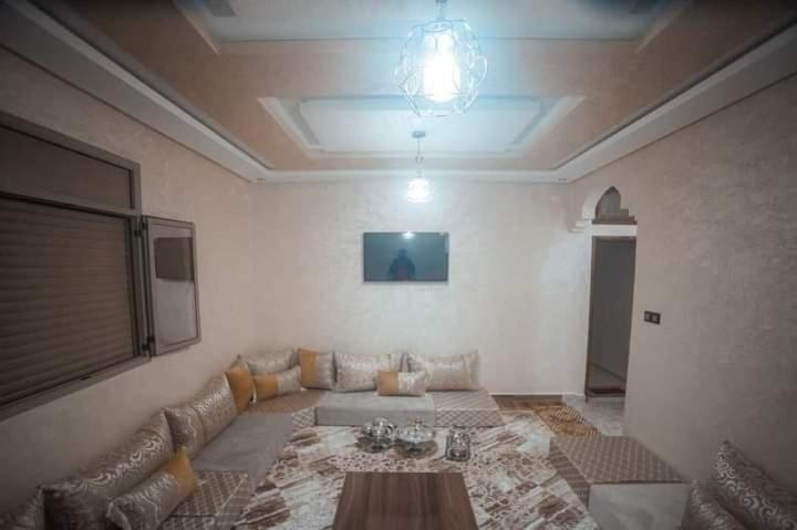 ein Wohnzimmer mit einem Sofa und einem Tisch in der Unterkunft Appartement Sable D'or in Tan-Tan