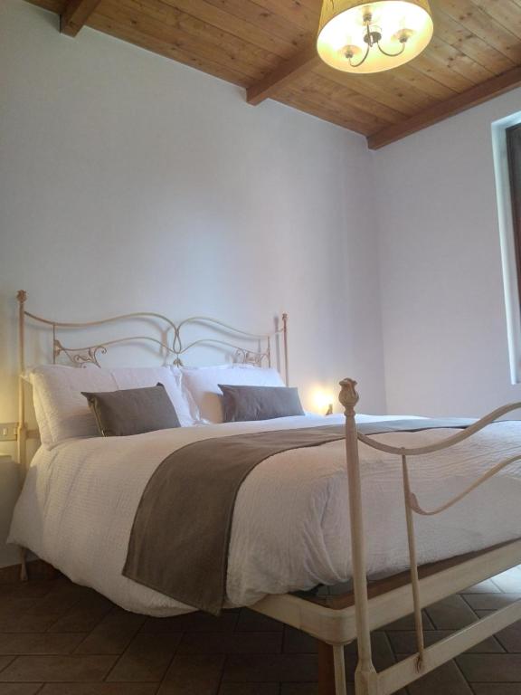 een slaapkamer met een groot bed en een houten plafond bij Il Borgo della Leti in Bergamo