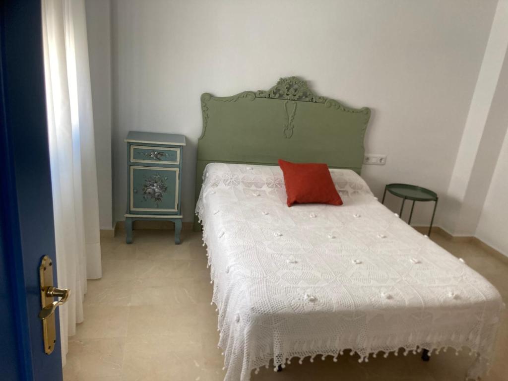 een slaapkamer met een bed met een rood kussen erop bij Casa helanna in El Puerto de Santa María