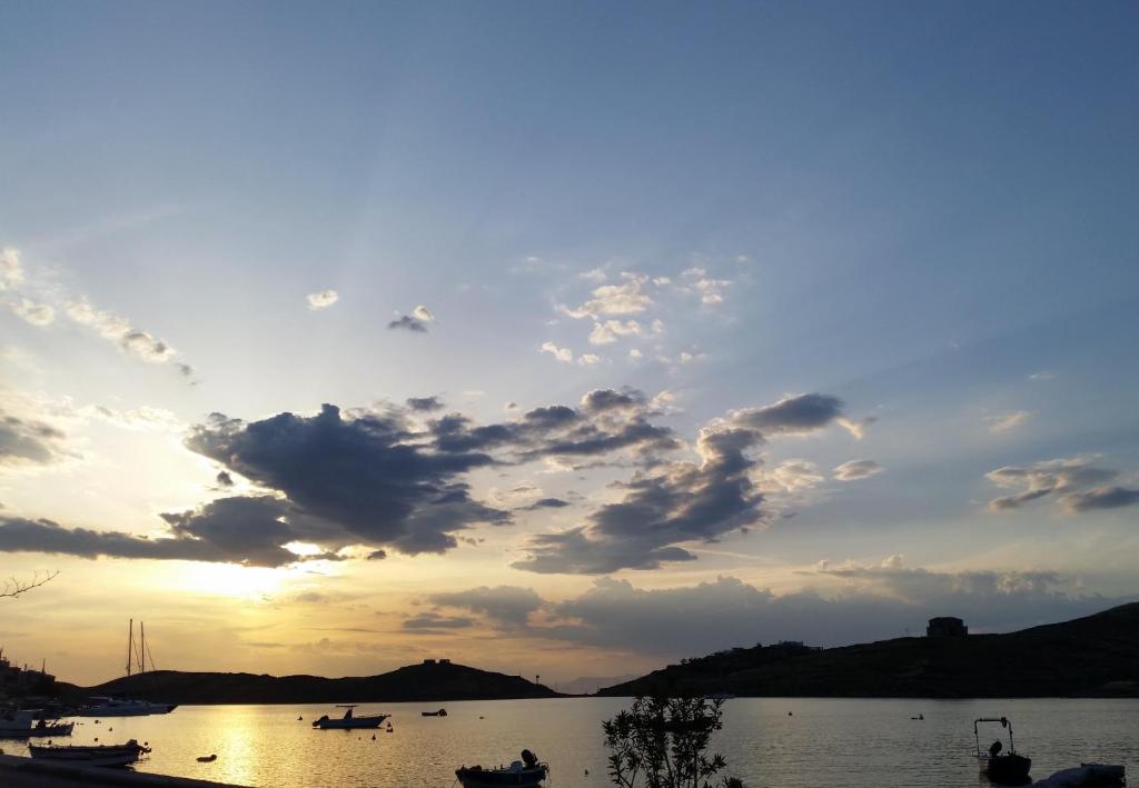 una puesta de sol sobre un lago con barcos en el agua en Charming Vourkari Stone Home 3 - Minutes from Port en Vourkarion