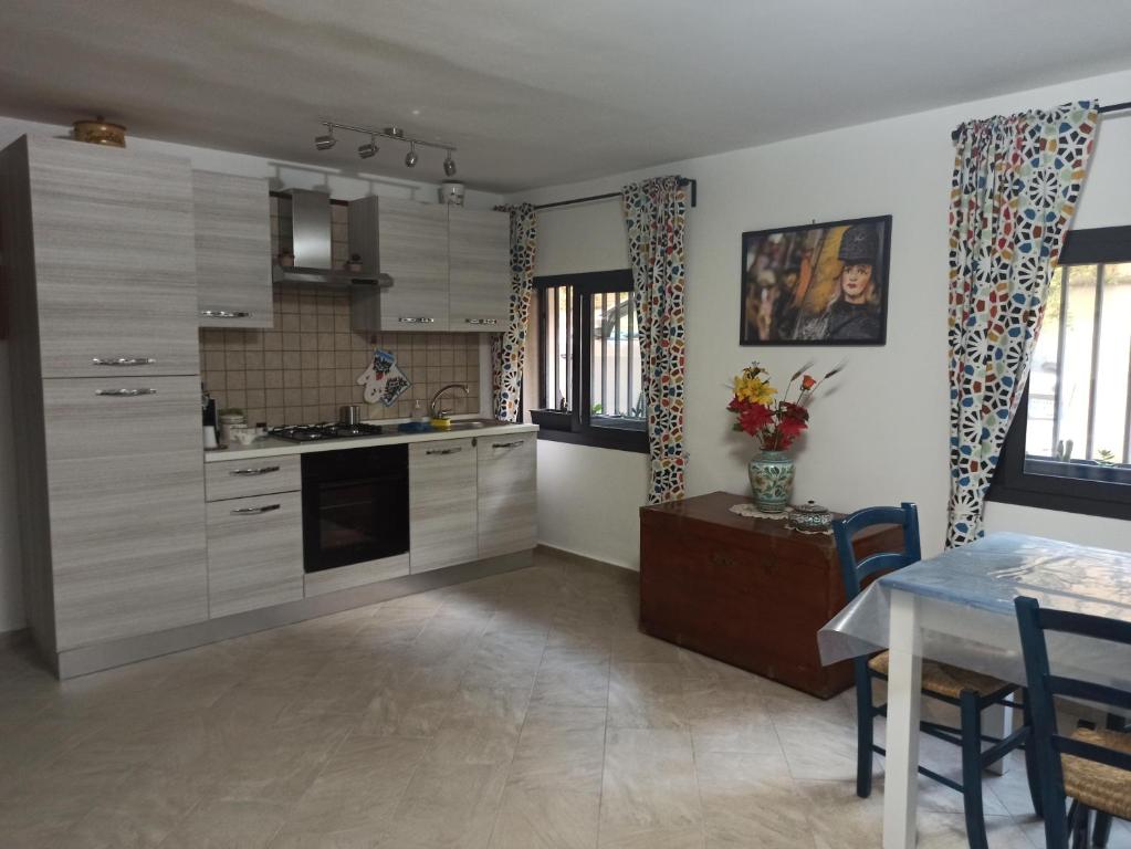eine Küche mit weißen Schränken, einem Tisch und einem Esszimmer in der Unterkunft Il paradiso nascosto in Catania