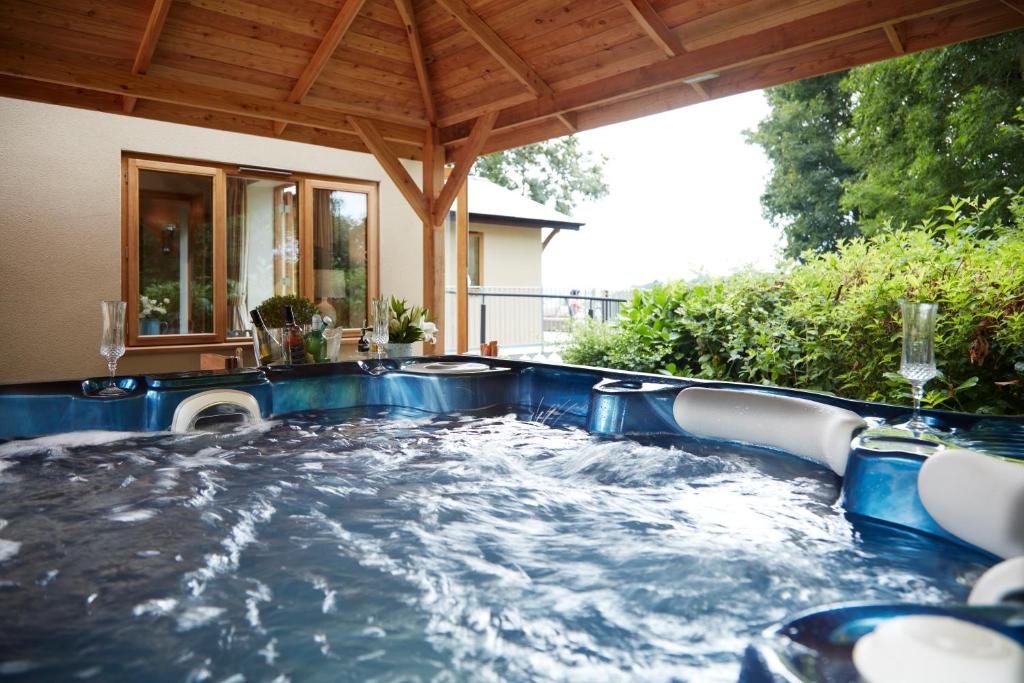 a hot tub in the backyard of a house at Upper Gelli Luxury Holiday Lodge, Converted Dairy & Cosy Shepherds Huts in Welshpool