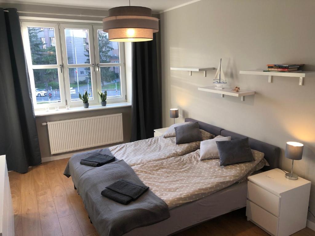 um quarto com uma cama grande e 2 janelas em Apartament BROWARNY em Ostrów Wielkopolski