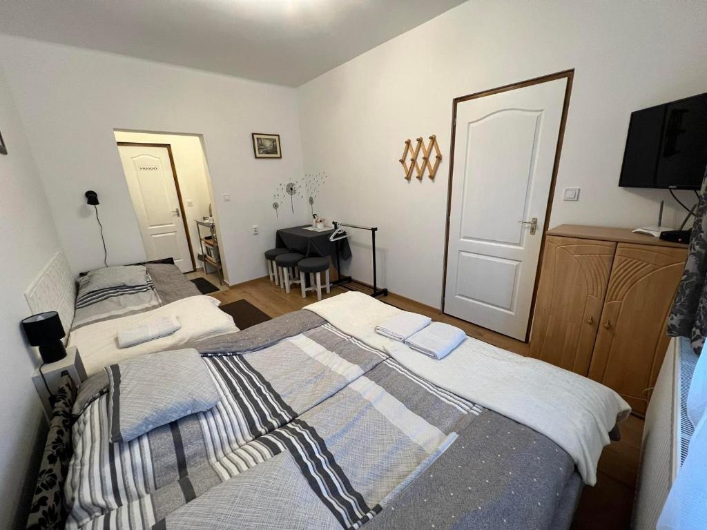 1 dormitorio con 2 camas y piano en Komáromi Vendégház Erdőhorváti en Erdőhorváti